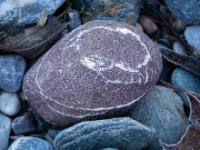 Rötlichbrauner Stein mit dünner weißen Ringmaserung